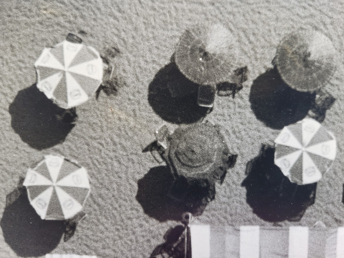Aerial view of Cadaques beach, huts and parasols on a sunny day by Michael Joseph