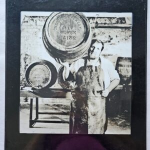 Chesters beer - bearded worker posing with barrel on shoulder, signed laminated darkroom print by Michael Joseph