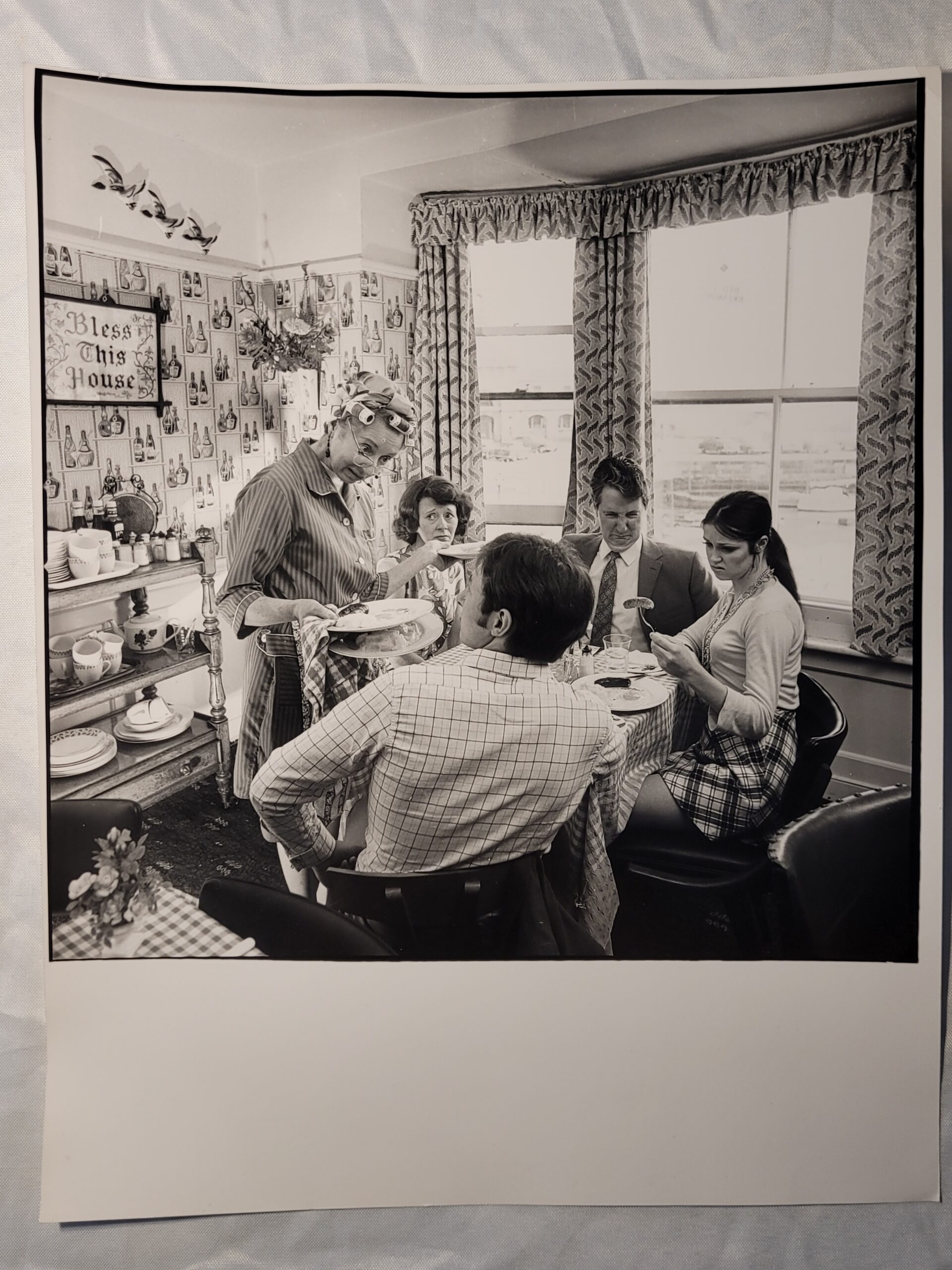 Family meal, housewife serving bangers and mash in curlers stereotypical british sixties household, by Michael Joseph