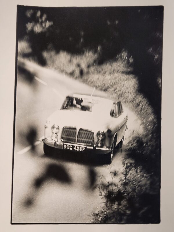 White car driving along a country lane, authentic darkroom photo in movement by Michael Joseph