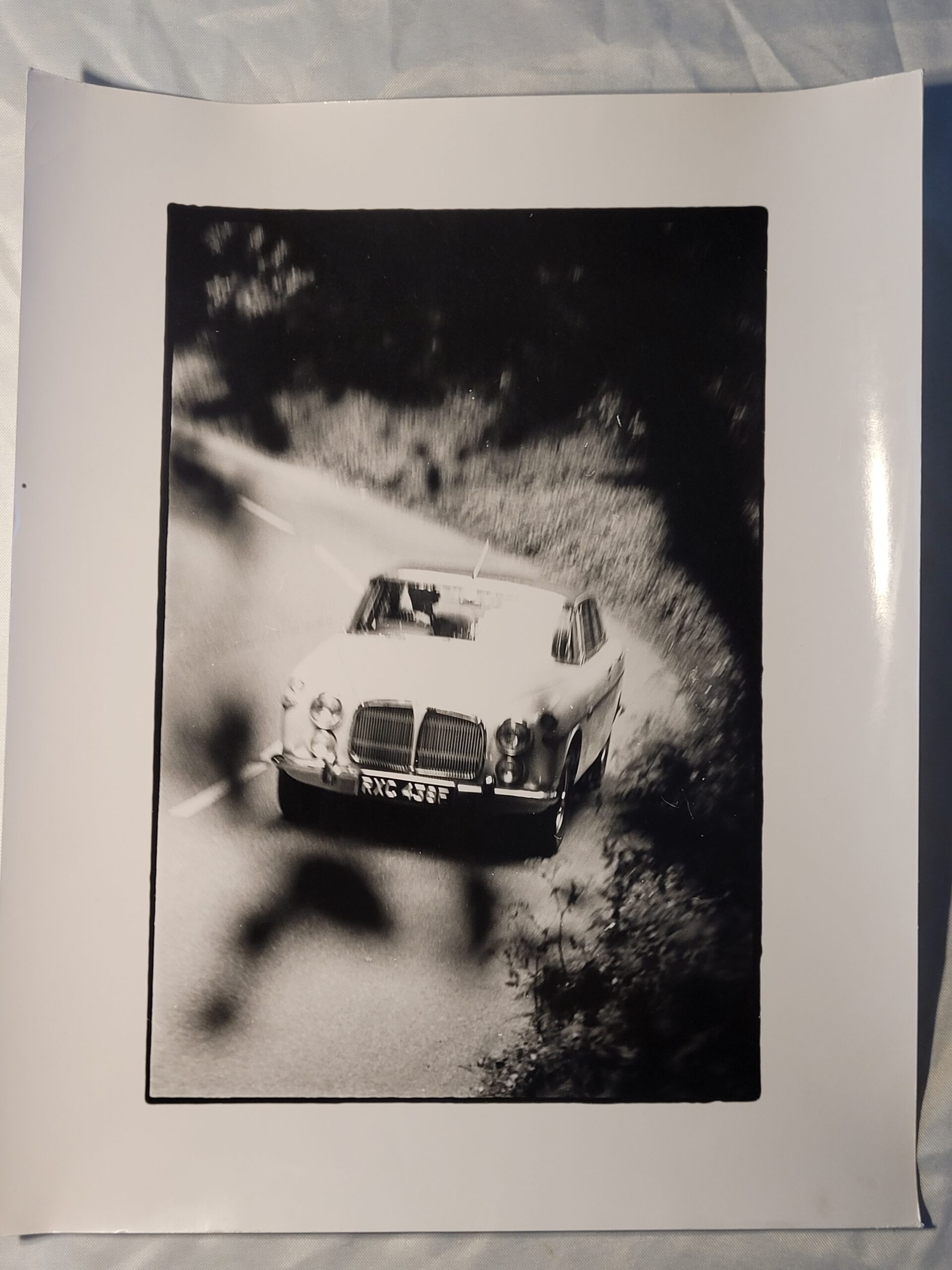 White car driving along a country lane, authentic darkroom photo in movement by Michael Joseph