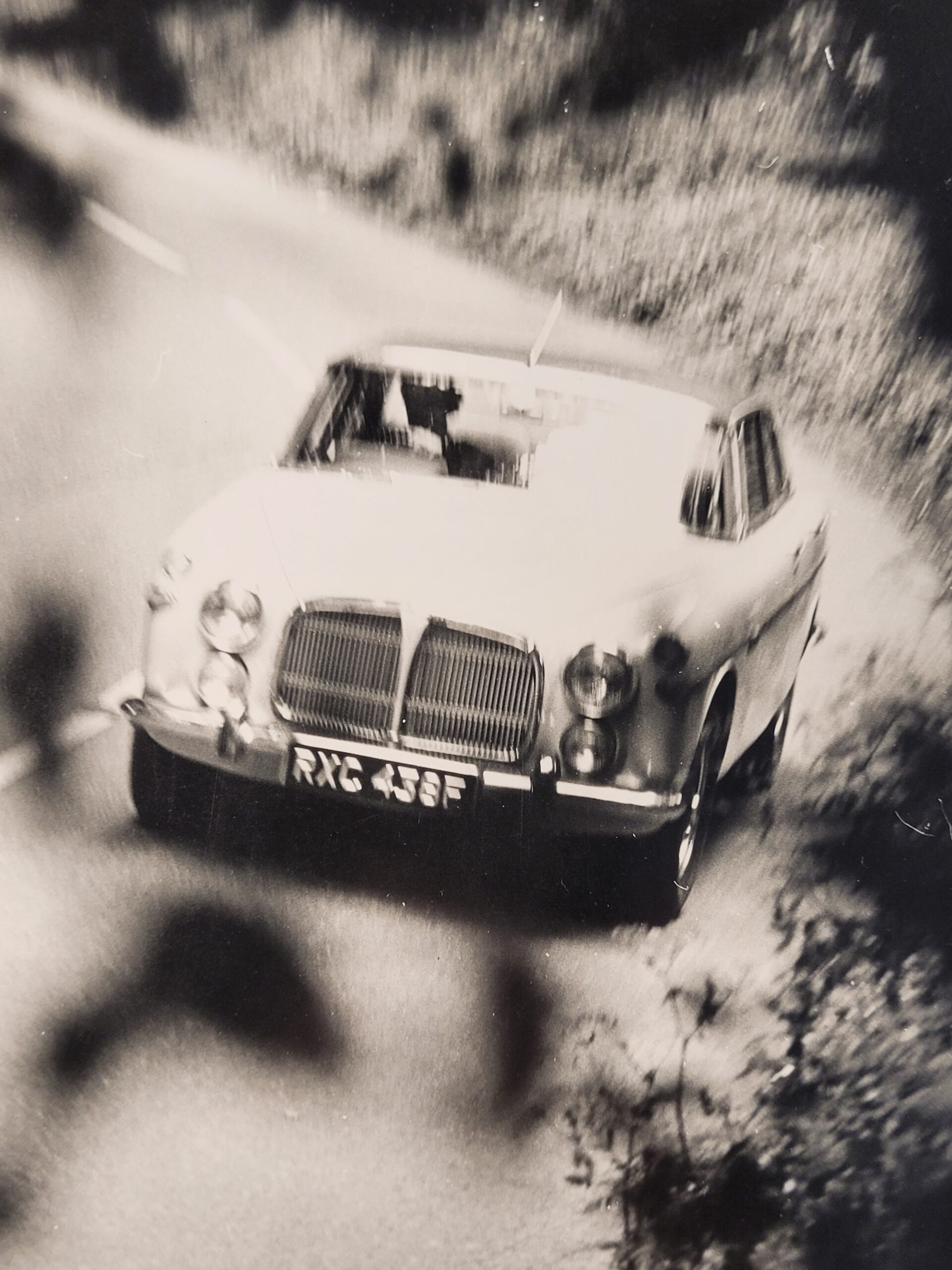 White car driving along a country lane, authentic darkroom photo in movement by Michael Joseph