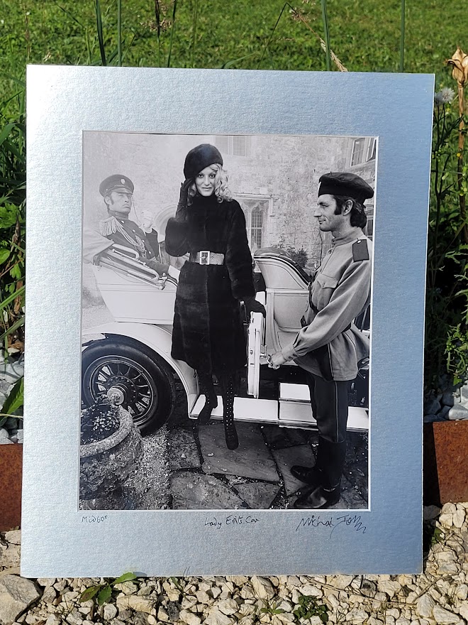 Brown-eyed blonde with fur hat and gestapo leaving car, seventies advert proof shot by Michael Joseph