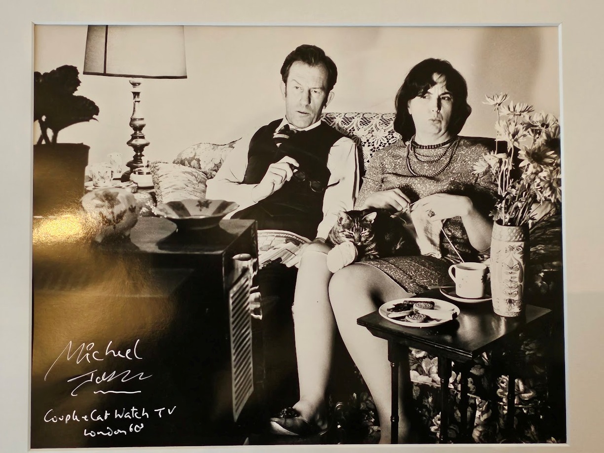 Couple watching TV in the lounge, stereotypical wife knitting with cat on lap, test print by Michael Joseph