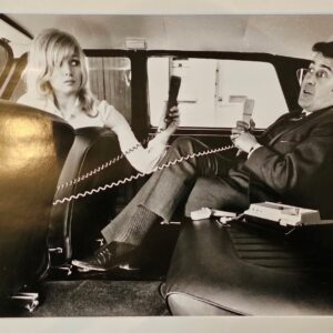 Couple with their carphones, carefree in a back of the car in the sixties by Michael Joseph