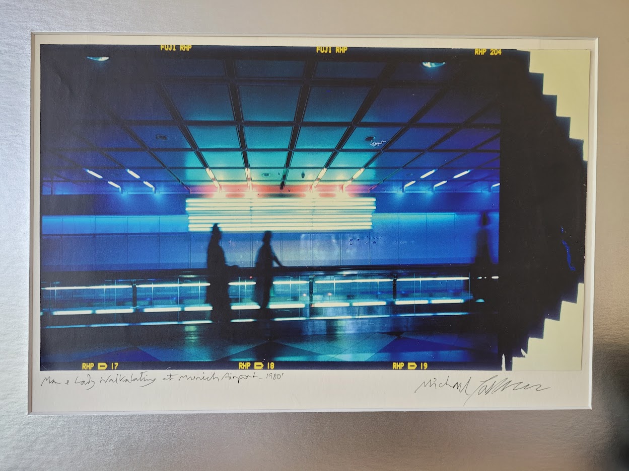 Silhouette d'un couple sur le trottoir roulant à l'aéroport de Munich, image à dominance bleue par Michael Joseph