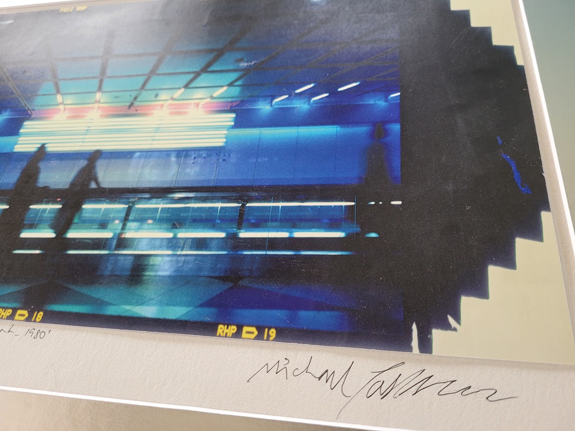 Silhouette d'un couple sur le trottoir roulant à l'aéroport de Munich, image à dominance bleue par Michael Joseph