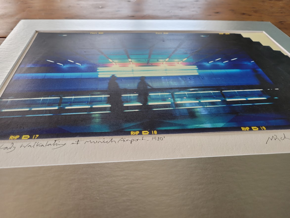 Silhouette d'un couple sur le trottoir roulant à l'aéroport de Munich, image à dominance bleue par Michael Joseph