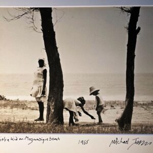 Mother with her children on Mozambique beach with austere trees and desertic seascape by Michael Joseph