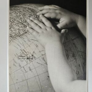 Child's hands on a globe, discovering the world is good, a timeless photograph by Michael Joseph