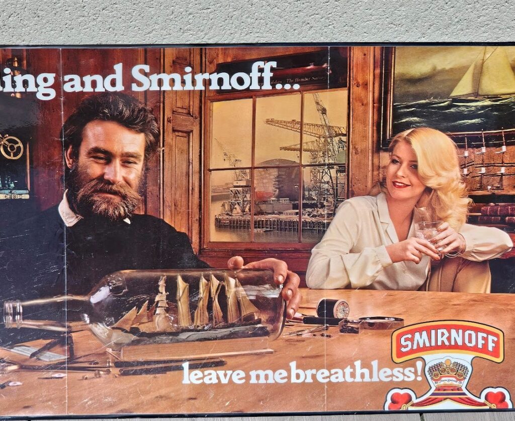 Shipbuilding and Smirnoff... leave me breathless! Vodka advertisement from the 1970s, bearded modelmaker and sexy blonde by Michael Joseph