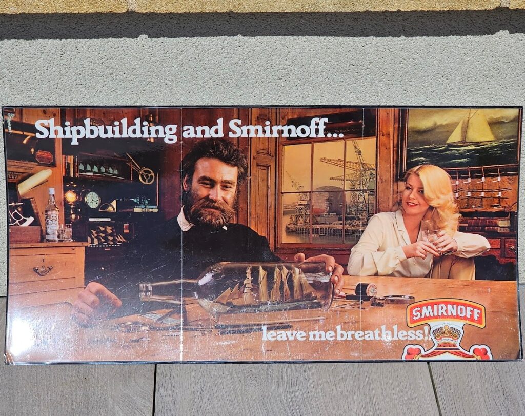 Shipbuilding and Smirnoff... leave me breathless! Vodka advertisement from the 1970s, bearded modelmaker and sexy blonde by Michael Joseph
