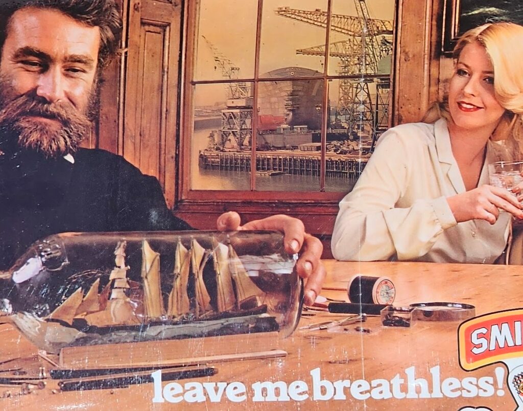 Shipbuilding and Smirnoff... leave me breathless! Vodka advertisement from the 1970s, bearded modelmaker and sexy blonde by Michael Joseph
