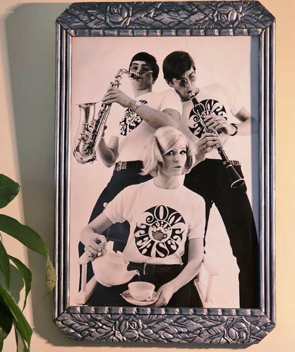 Join the Tea Set blonde pouring tea, guys clarinette and Saxophone, tea-set t-shirts by Michael Joseph, silver and peacock-blue floral delight frame