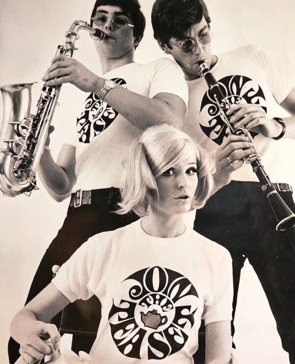 Join the Tea Set blonde pouring tea, guys clarinette and Saxophone, tea-set t-shirts by Michael Joseph, silver and peacock-blue floral delight frame