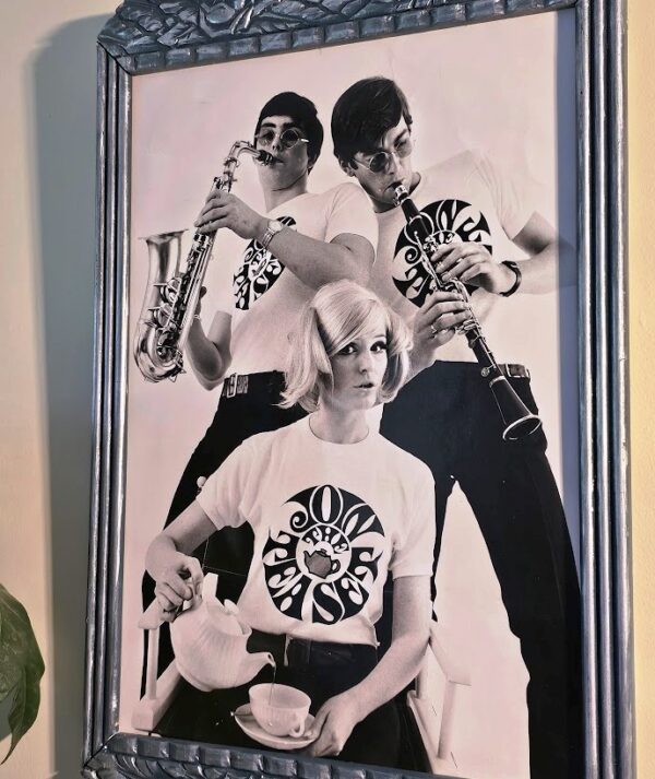 Join the Tea Set blonde pouring tea, guys clarinette and Saxophone, tea-set t-shirts by Michael Joseph, silver and peacock-blue floral delight frame