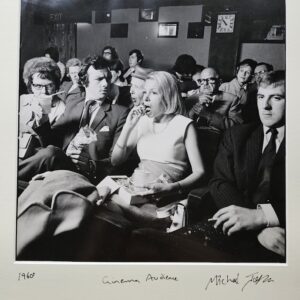 Femme des années 60 en train de manger au cinéma, avec son voisin visiblement agacé – les émotions à leur comble